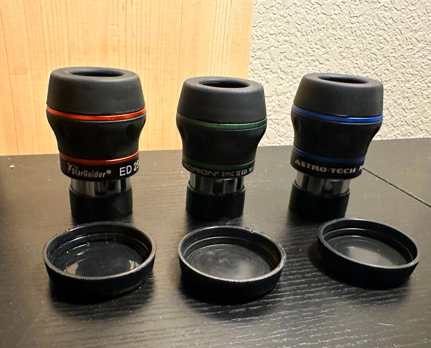 A beginner-friendly astronomy setup on a patio at dusk, with a Dobsonian telescope and several eyepieces laid out neatly on a small table