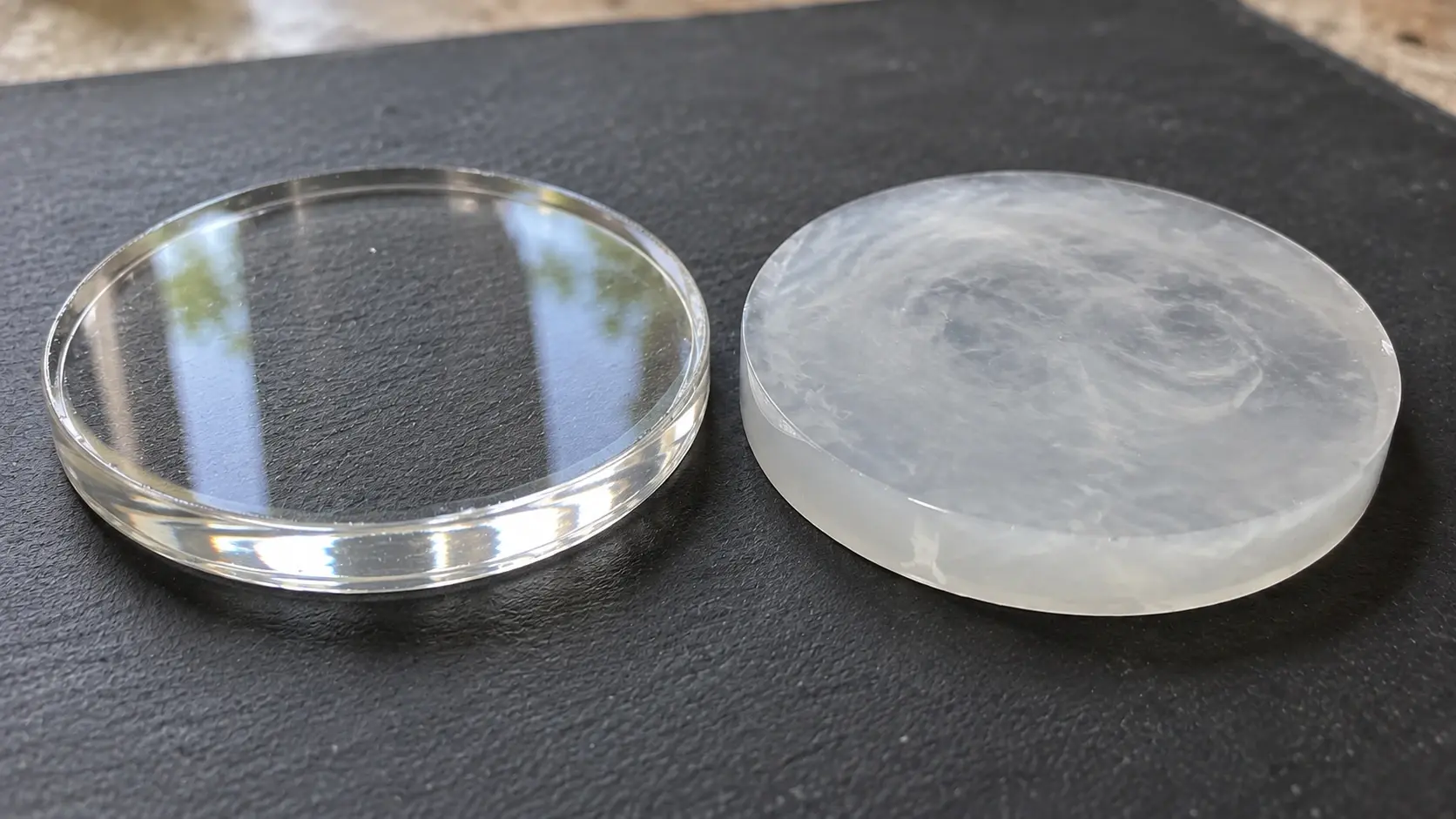 A photo of a resin coaster on a craft table showing a milky, cloudy patch in an otherwise clear pour with tools and gloves nearby