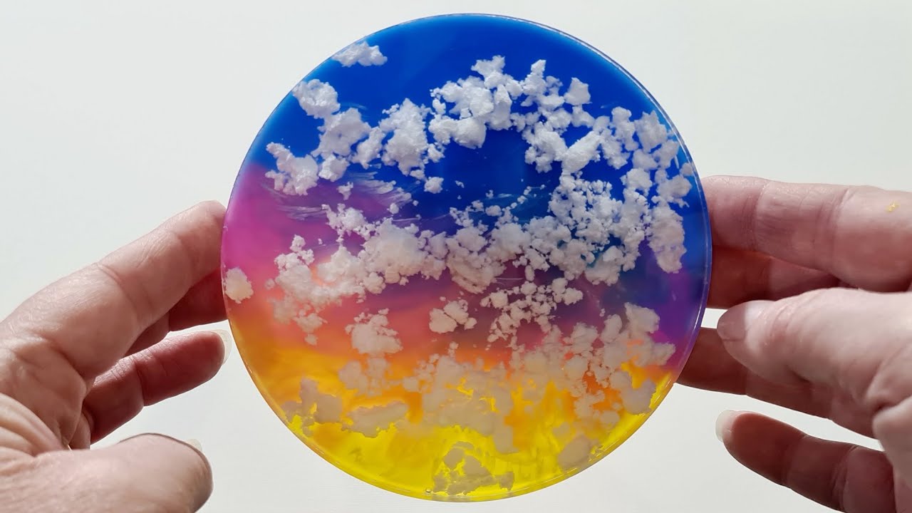 A photograph of a cured resin coaster on a wooden table showing a cloudy, milky haze in the center under natural light