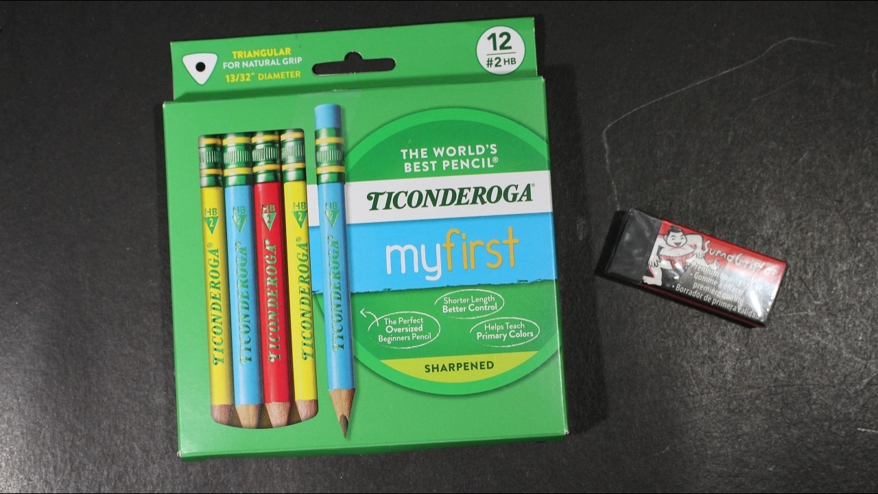 A small set of pencils labeled HB and 2B laid out next to a sharpener and eraser on a desk
